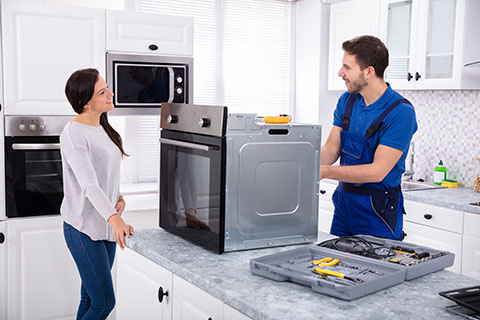 satisfied customer smiling at appliance repair technician